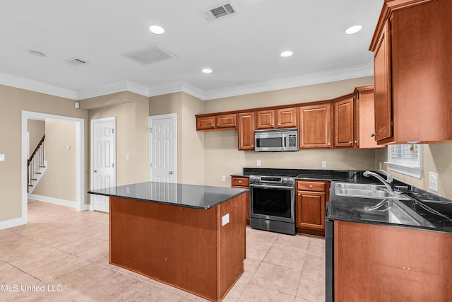 kitchen with a center island, light tile patterned flooring, sink, appliances with stainless steel finishes, and ornamental molding