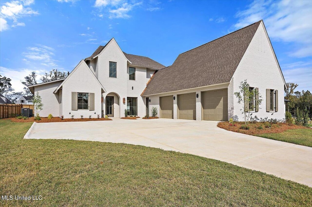 view of front of home featuring a front yard, a garage, and central AC unit