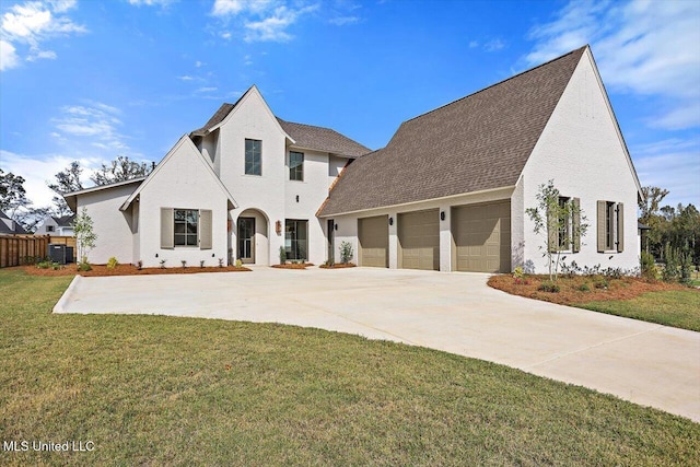 view of front of home featuring a front yard, a garage, and central AC unit