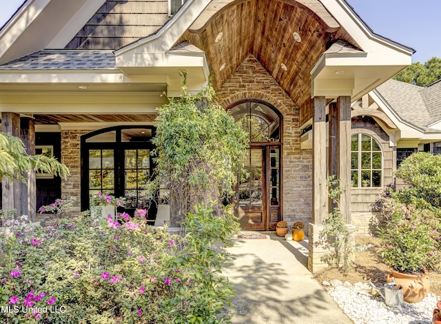 entrance to property featuring a shingled roof and french doors