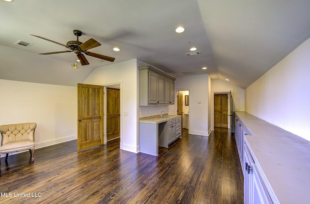 interior space with open floor plan, vaulted ceiling, visible vents, and gray cabinets