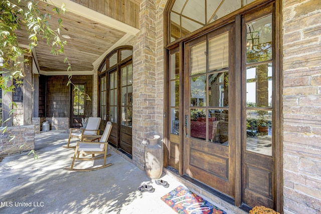 entrance to property with a porch and french doors