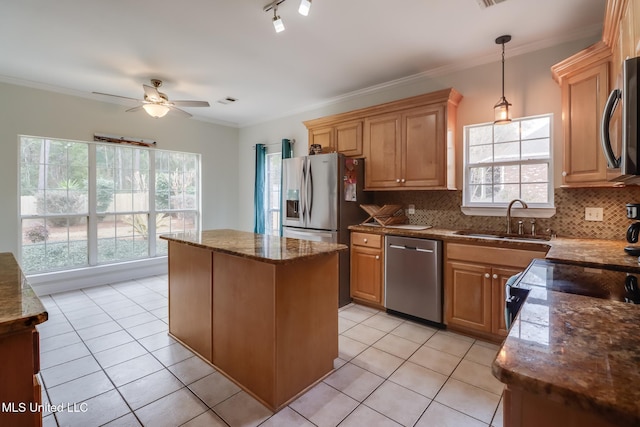 kitchen featuring pendant lighting, sink, crown molding, stainless steel appliances, and a center island