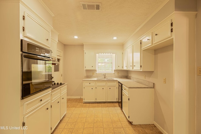 kitchen featuring visible vents, stainless steel dishwasher, a sink, baseboards, and oven