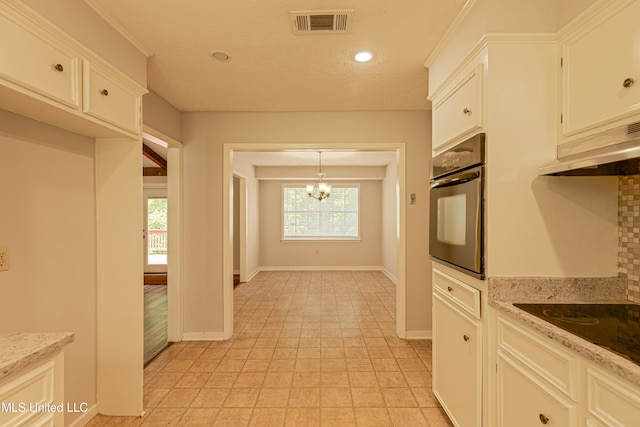 kitchen with visible vents, baseboards, black appliances, a notable chandelier, and under cabinet range hood