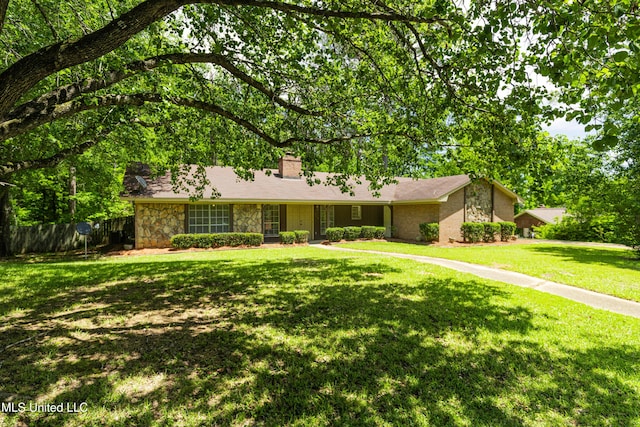 ranch-style home featuring fence, a chimney, a front lawn, and stone siding