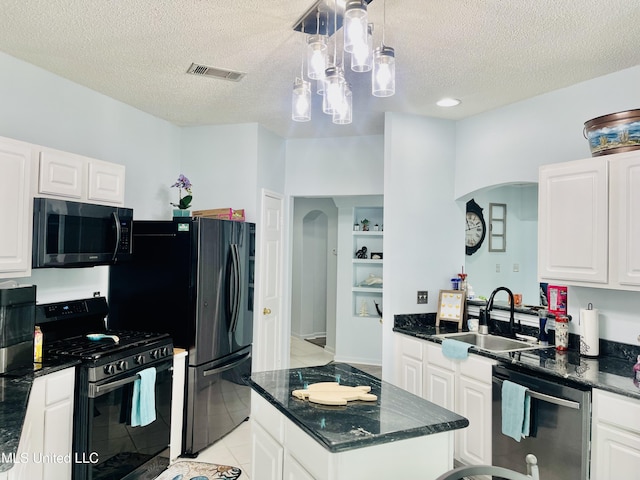 2252 Beach Dr Unit 305, Gulfport, MS 39507 - kitchen featuring stainless steel appliances, a sink, arched walkways, a textured ceiling, and white cabinets