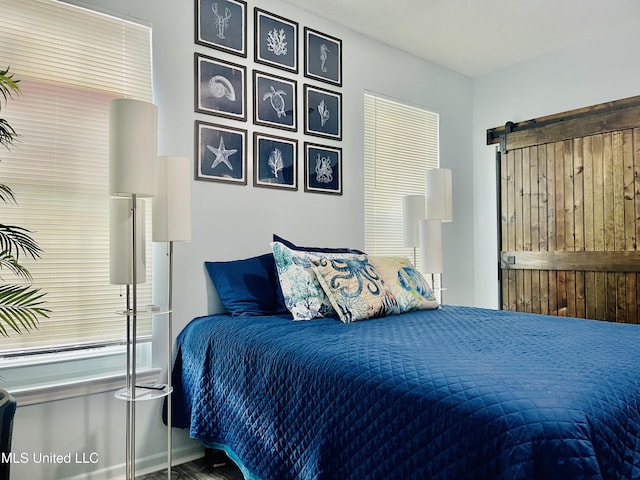 2252 Beach Dr Unit 305, Gulfport, MS 39507 - bedroom with a barn door and wood finished floors