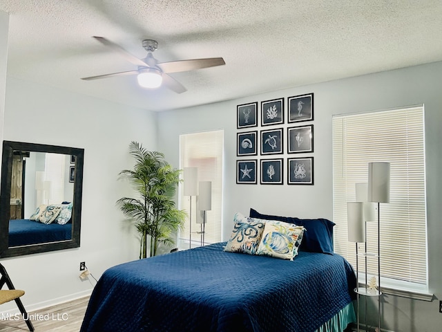 2252 Beach Dr Unit 305, Gulfport, MS 39507 - bedroom with wood finished floors, baseboards, a textured ceiling, and a ceiling fan
