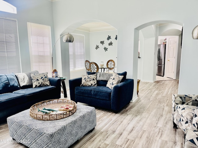 2252 Beach Dr Unit 305, Gulfport, MS 39507 - living room featuring arched walkways, crown molding, light wood-type flooring, and baseboards