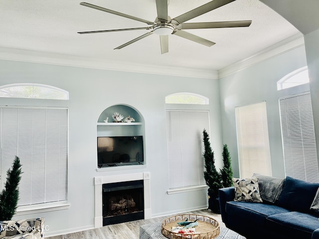 2252 Beach Dr Unit 305, Gulfport, MS 39507 - living area featuring ornamental molding, a ceiling fan, a fireplace, wood finished floors, and built in shelves
