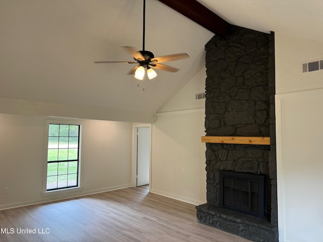 unfurnished living room featuring light wood-type flooring, a stone fireplace, ceiling fan, beam ceiling, and high vaulted ceiling