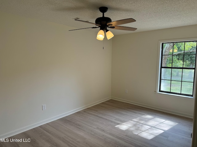 empty room featuring a textured ceiling, light hardwood / wood-style floors, and ceiling fan