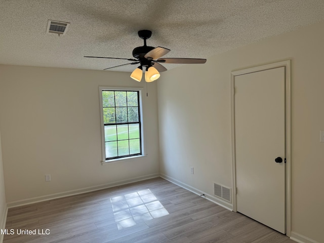 unfurnished room with light hardwood / wood-style flooring, a textured ceiling, and ceiling fan