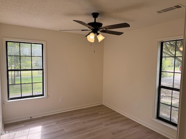 unfurnished room with ceiling fan, light hardwood / wood-style floors, and plenty of natural light