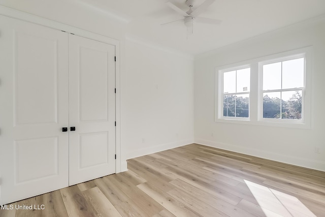 unfurnished bedroom with ceiling fan, light wood-type flooring, and a closet