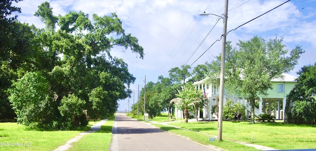 view of road featuring street lighting, sidewalks, and curbs