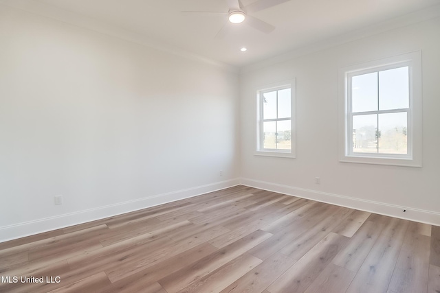 empty room with light hardwood / wood-style flooring, plenty of natural light, and ornamental molding