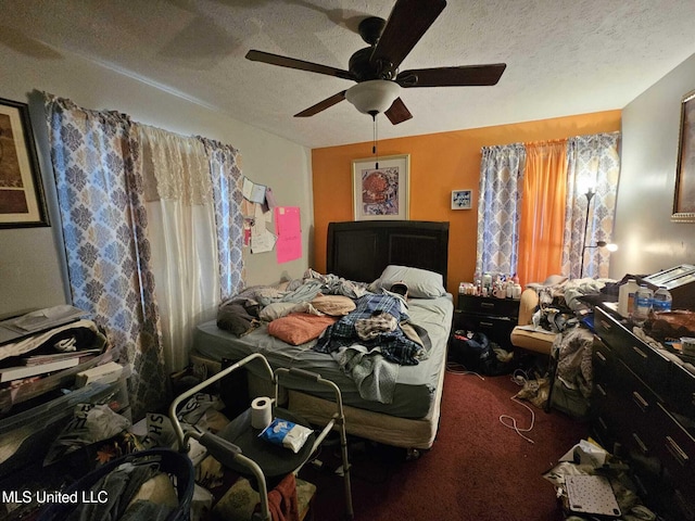 bedroom with ceiling fan, a textured ceiling, and dark colored carpet