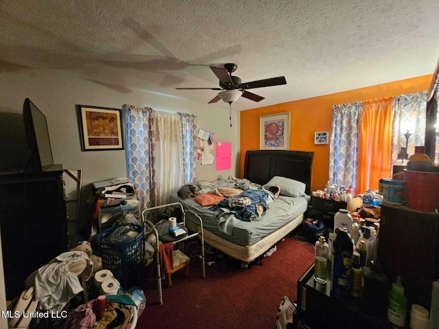 carpeted bedroom featuring ceiling fan, multiple windows, and a textured ceiling