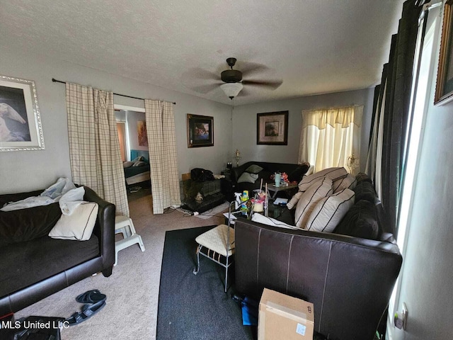 carpeted living room with a textured ceiling and ceiling fan