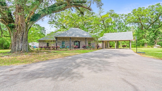 view of front of property with aphalt driveway, a front lawn, and a carport