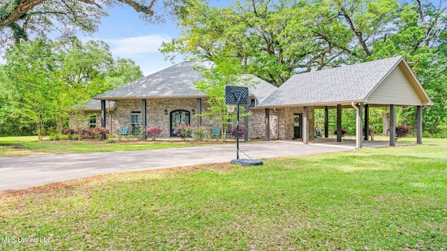 view of front of house featuring brick siding, aphalt driveway, a front lawn, and roof with shingles