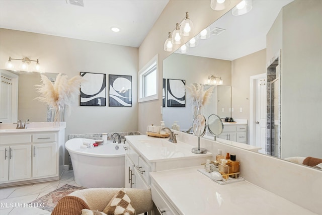 full bath featuring visible vents, marble finish floor, a freestanding bath, and a sink