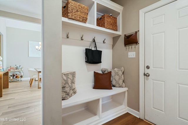 mudroom featuring an inviting chandelier, baseboards, and wood finished floors