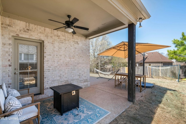 view of patio with outdoor dining space, a ceiling fan, and fence