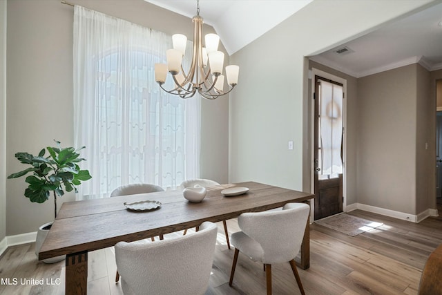 dining room with visible vents, ornamental molding, wood finished floors, baseboards, and vaulted ceiling