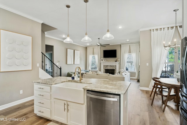 kitchen featuring a sink, light wood-style floors, dishwasher, crown molding, and ceiling fan with notable chandelier