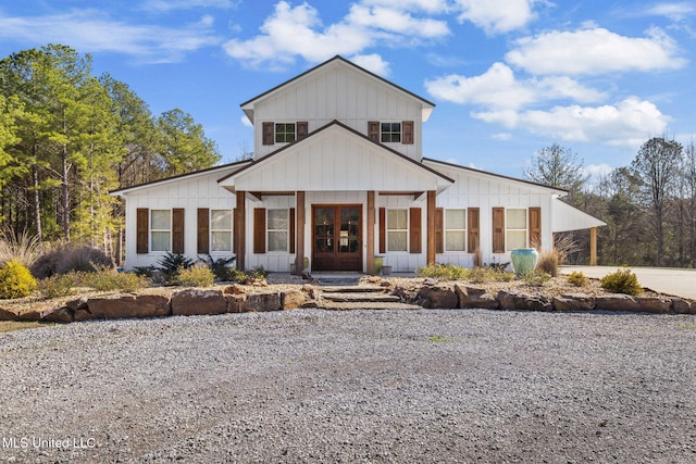 view of front of house with board and batten siding, french doors, and driveway