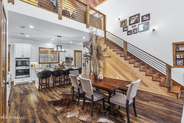 dining space featuring stairs, visible vents, dark wood-type flooring, and recessed lighting