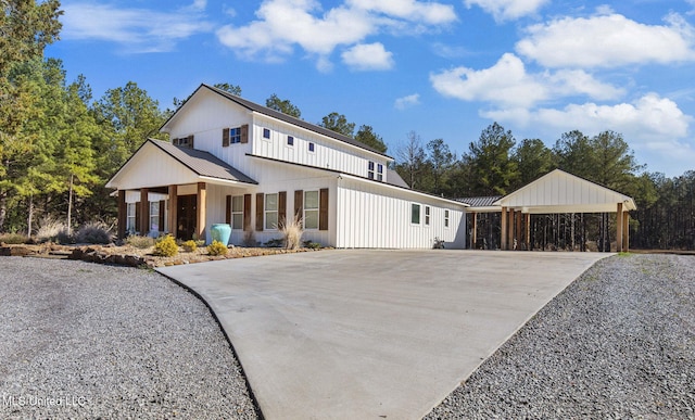 modern farmhouse with driveway and metal roof