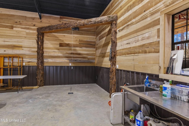 interior space with wooden walls and unfinished concrete flooring