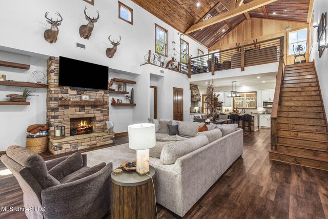 living area with wooden ceiling, stairway, dark wood-style flooring, and a stone fireplace