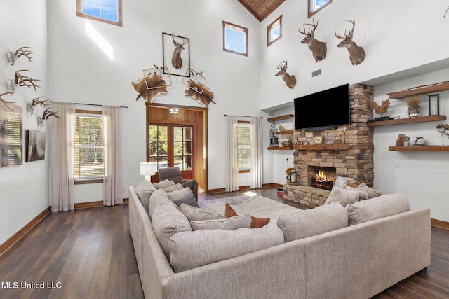 living area featuring dark wood-style flooring, visible vents, a fireplace, and baseboards