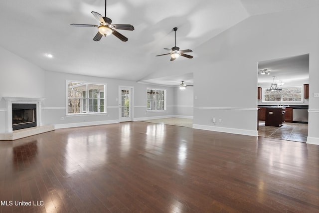 unfurnished living room with a glass covered fireplace, baseboards, and wood finished floors