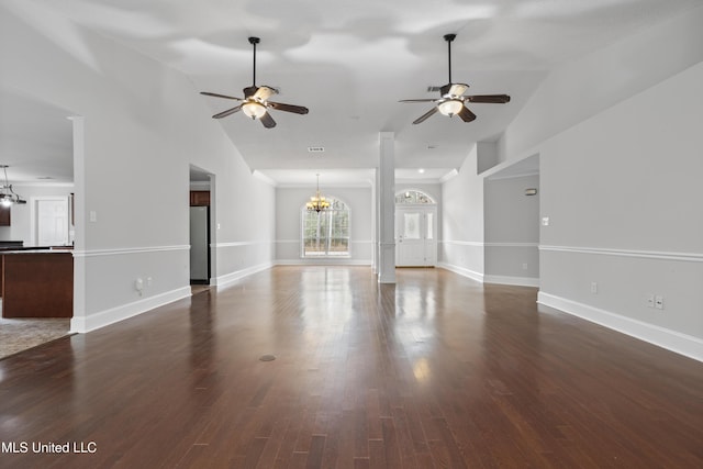 unfurnished living room featuring dark wood-style floors, baseboards, vaulted ceiling, and ceiling fan with notable chandelier