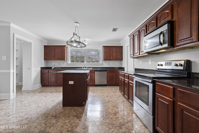 kitchen with a center island, stainless steel appliances, dark countertops, visible vents, and ornamental molding