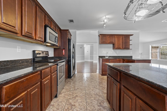 kitchen with visible vents, appliances with stainless steel finishes, dark stone counters, and a sink