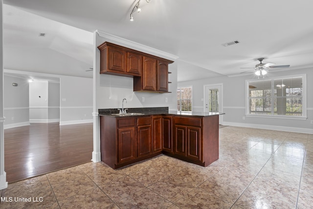 kitchen with ceiling fan, a sink, visible vents, baseboards, and open floor plan