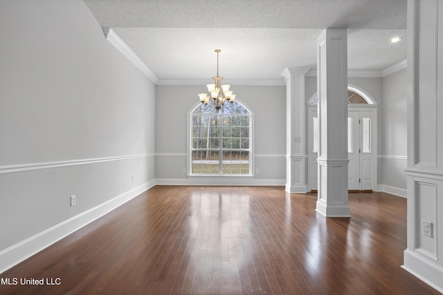 unfurnished dining area featuring ornate columns, a textured ceiling, and dark wood-style flooring