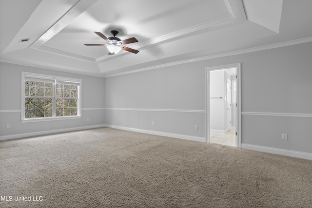 unfurnished room featuring ceiling fan, light colored carpet, baseboards, ornamental molding, and a raised ceiling