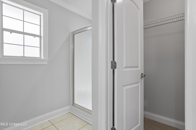 bathroom with a stall shower, tile patterned flooring, and baseboards