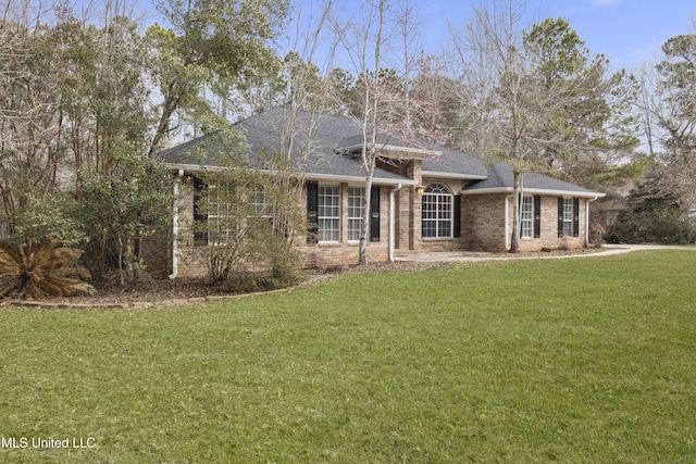 ranch-style house featuring a front yard, brick siding, and roof with shingles