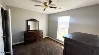 bedroom featuring ceiling fan and dark carpet