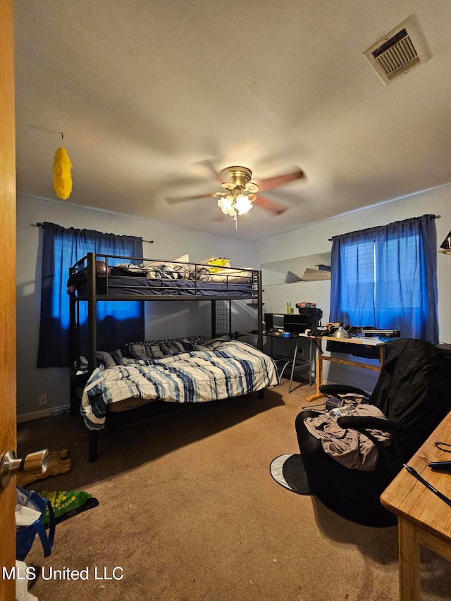 bedroom featuring a textured ceiling, carpet flooring, and ceiling fan