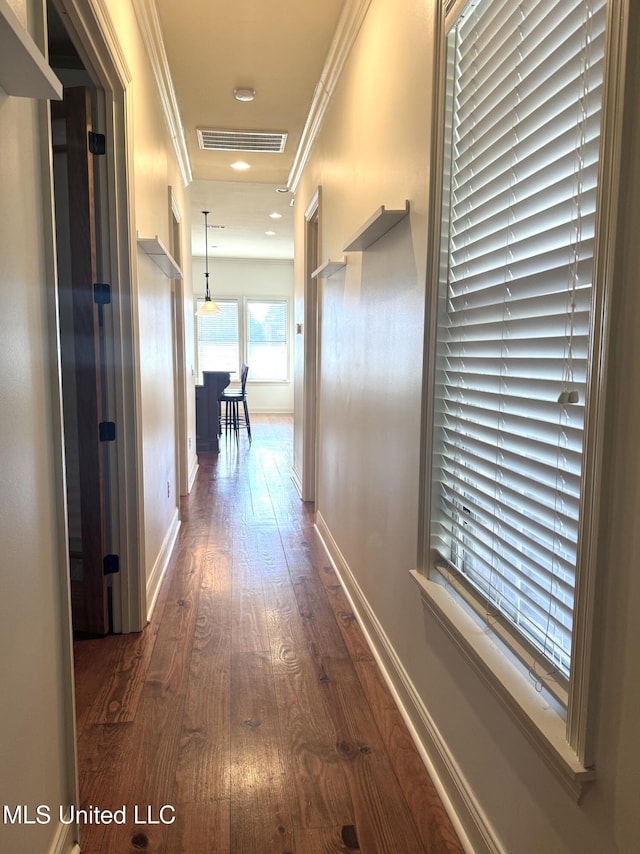 corridor featuring ornamental molding and dark hardwood / wood-style flooring